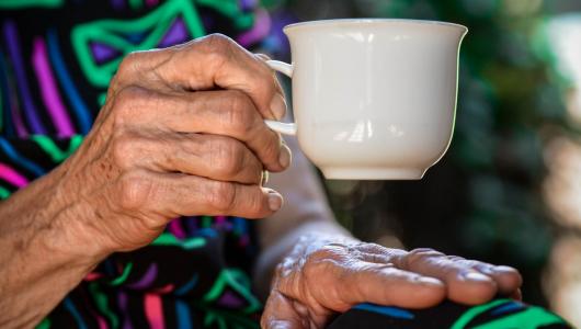 Äldre person håller en kaffekopp
